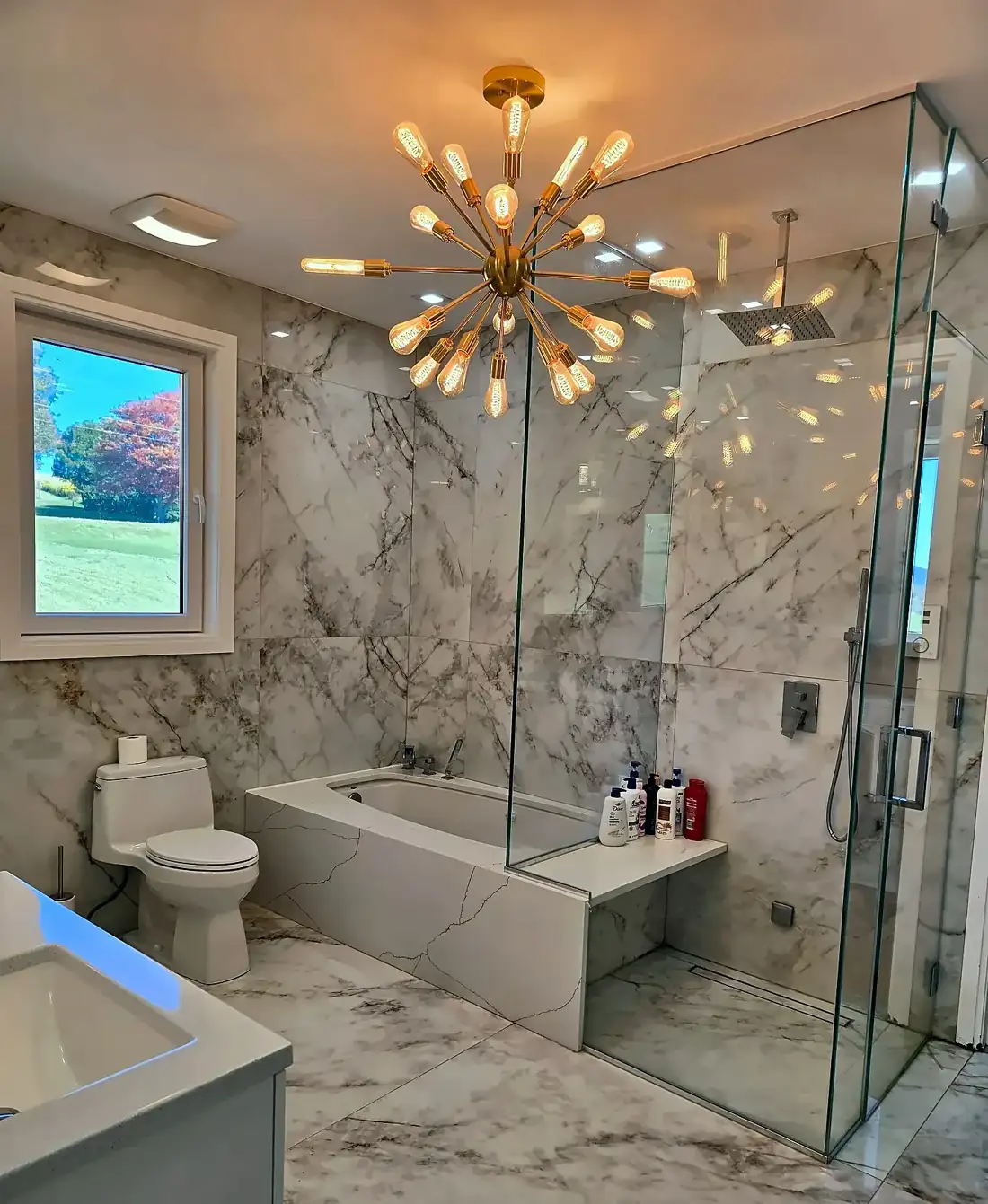 Bathroom with marble walls, tub and chandelier