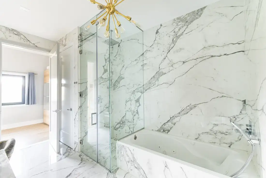 Marble bathroom with tub and glass shower