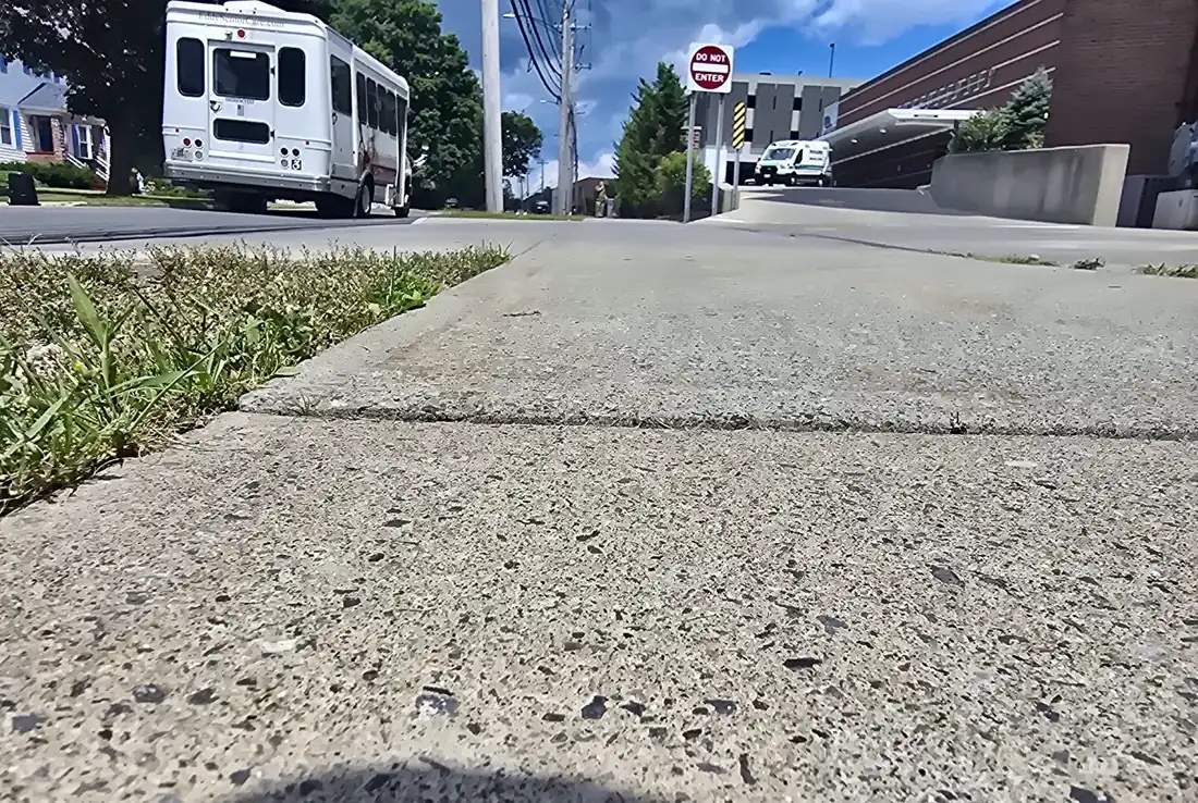 Heaved and spalled sidewalk panel before