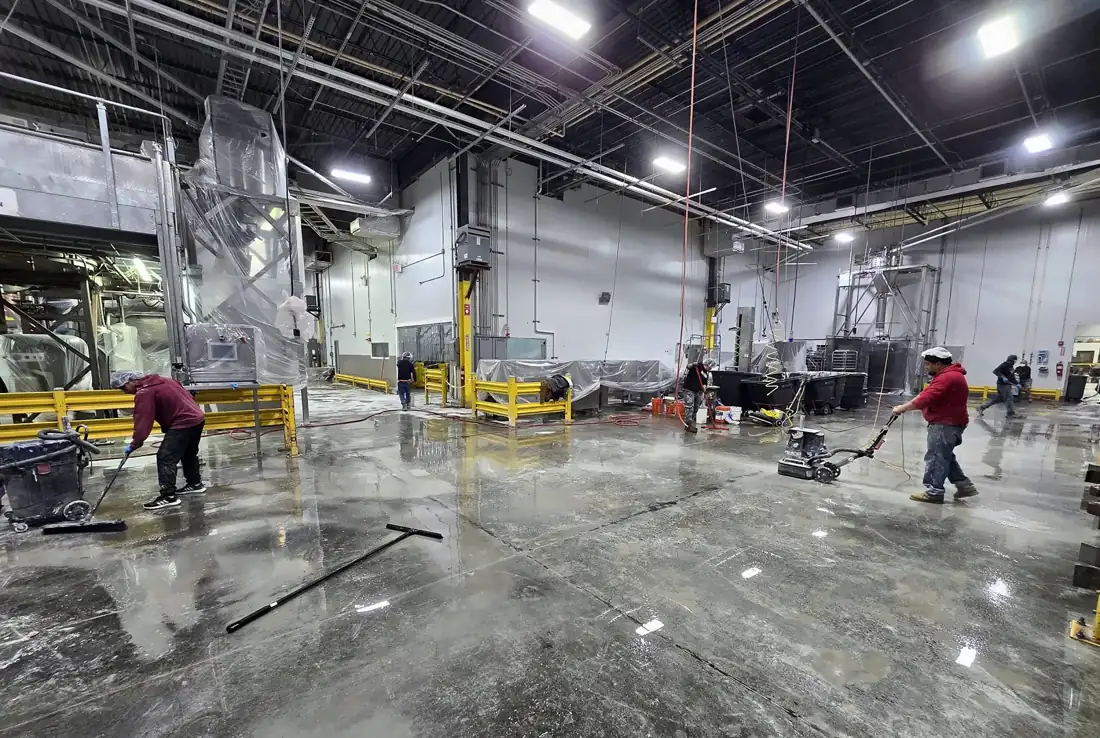 Crew grinding an industrial floor before coating