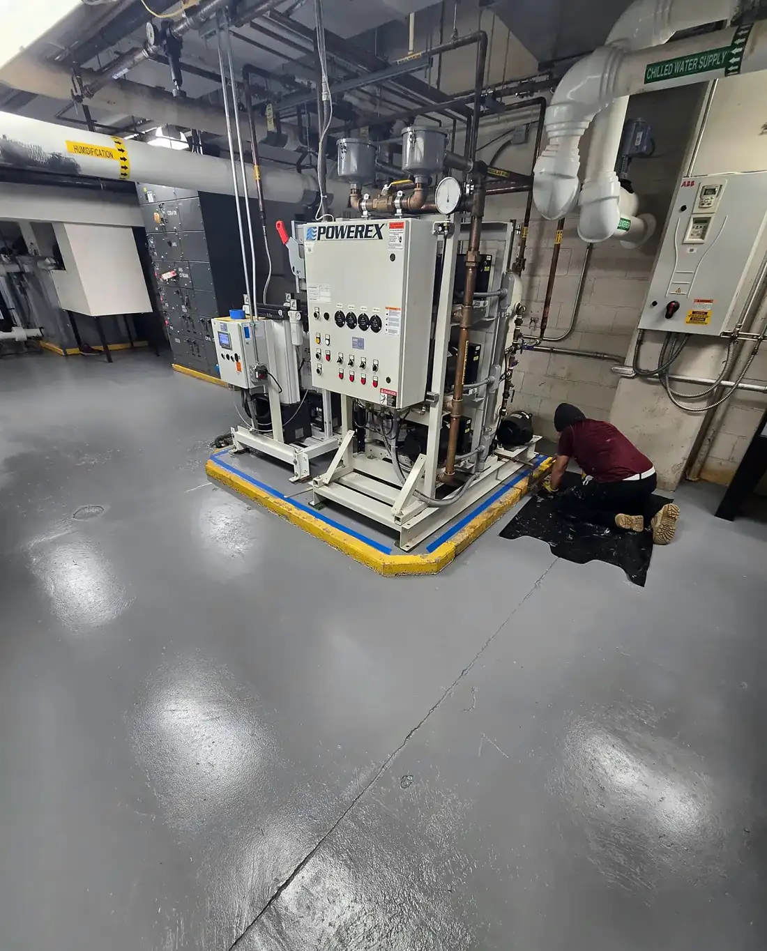 Same room after grinding, crack repair and gray epoxy with safety striping
